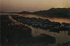 Porto interior ao pôr-do-sol / photo by M. Cardoso. - Macau : Dept. of Information and Tourism, (C.I.T.), [ca 1982] (Macau: : Mandarin Printing Press). - 1 postal : color. ; 10,5x15,5 cm